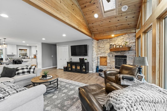 living area featuring recessed lighting, a fireplace, baseboards, and wood finished floors