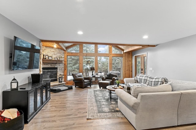 living room with vaulted ceiling with beams, light wood finished floors, a fireplace, and recessed lighting