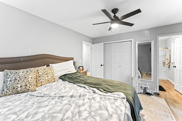 bedroom with a closet, ceiling fan, baseboards, and wood finished floors