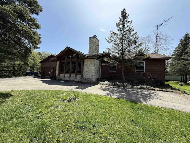 5235 Lahring Rd, Linden, MI 48451 - view of front of property with an attached garage, a front lawn, driveway, and a chimney