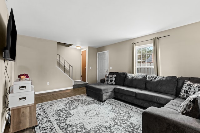 living area featuring stairway, baseboards, and wood finished floors