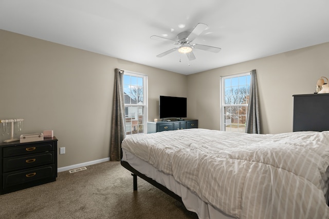 bedroom with carpet floors, multiple windows, baseboards, and a ceiling fan