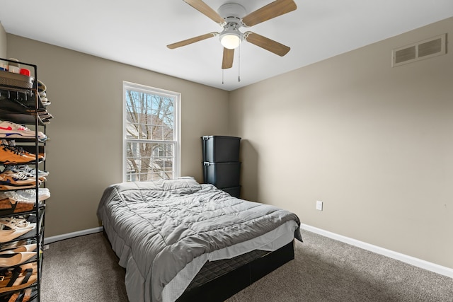 carpeted bedroom featuring a ceiling fan, visible vents, and baseboards