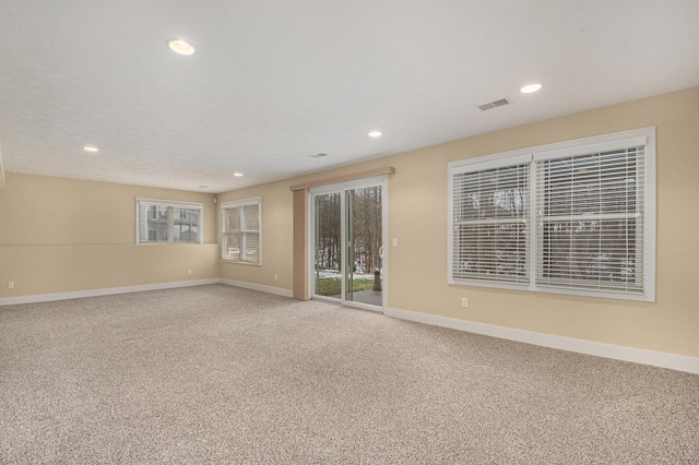 spare room featuring carpet, visible vents, baseboards, and recessed lighting