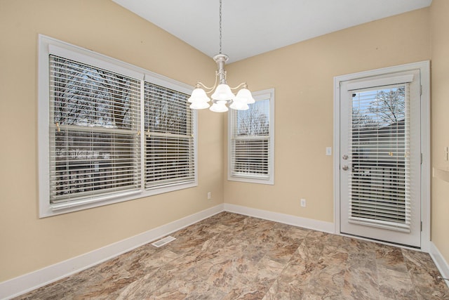 unfurnished dining area featuring baseboards, visible vents, and an inviting chandelier