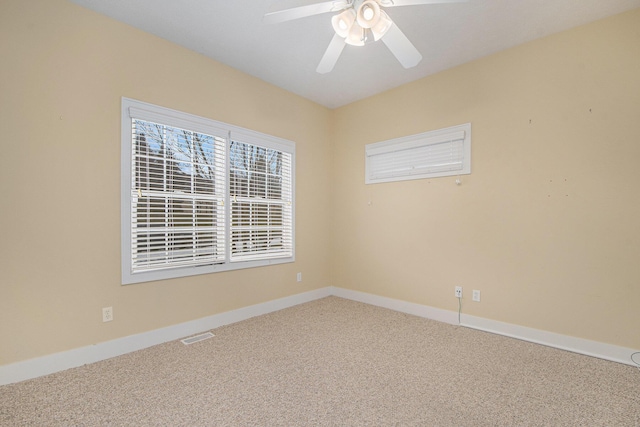 carpeted spare room with ceiling fan, visible vents, and baseboards