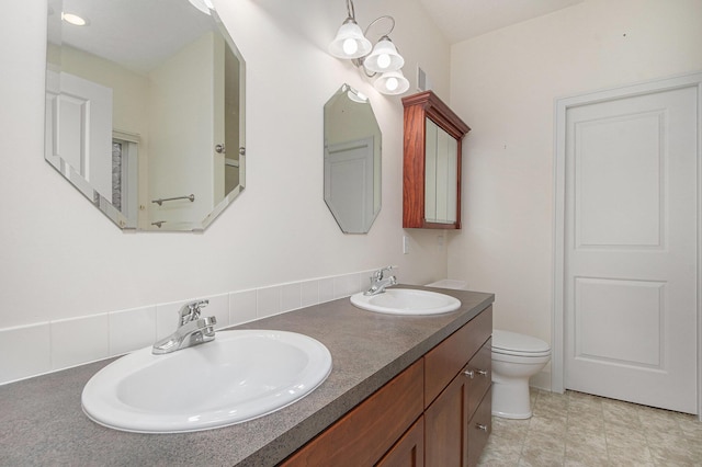 full bathroom featuring a sink, toilet, and double vanity