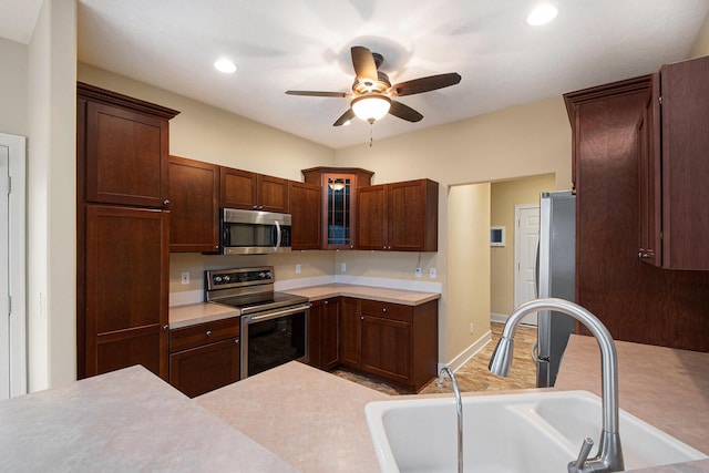 kitchen with a ceiling fan, stainless steel appliances, a sink, and light countertops