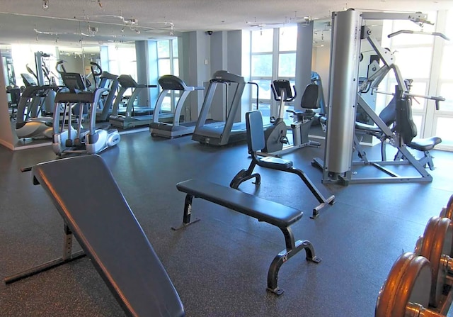 gym with a textured ceiling and floor to ceiling windows