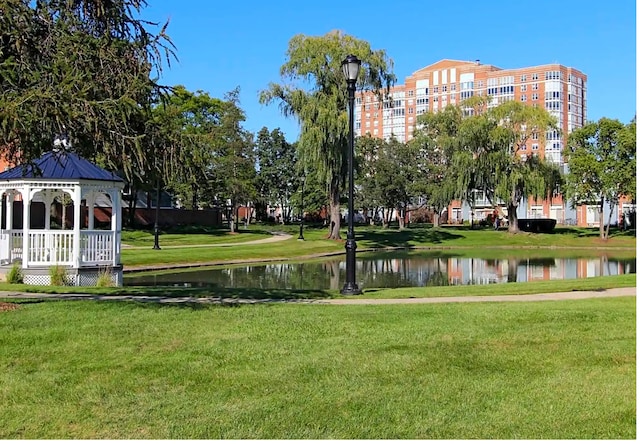 surrounding community with a water view, a gazebo, and a yard