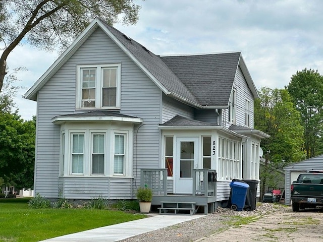 view of front facade with roof with shingles