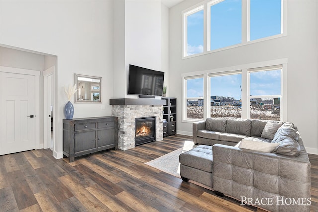 living area with a fireplace, baseboards, and dark wood-style flooring