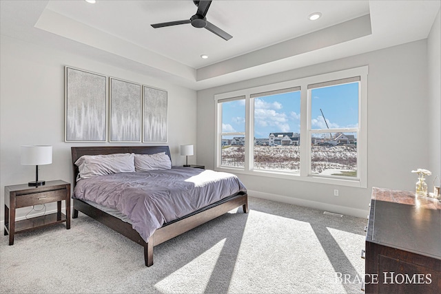 bedroom with baseboards, ceiling fan, carpet, a tray ceiling, and recessed lighting