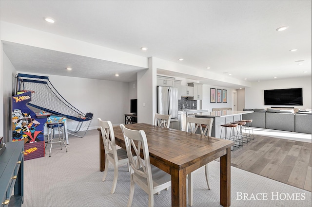 dining area featuring baseboards, light wood-style flooring, and recessed lighting