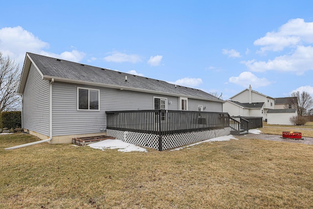 rear view of property featuring a deck and a yard