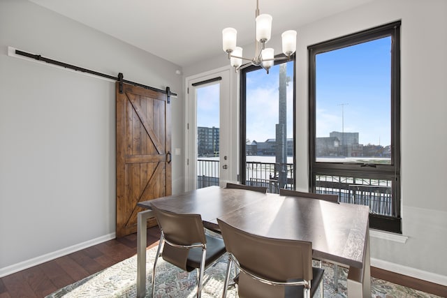 dining room with a barn door, dark wood-style flooring, plenty of natural light, and a city view