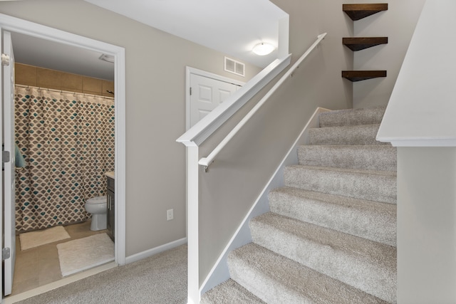 stairway featuring carpet flooring, visible vents, and baseboards