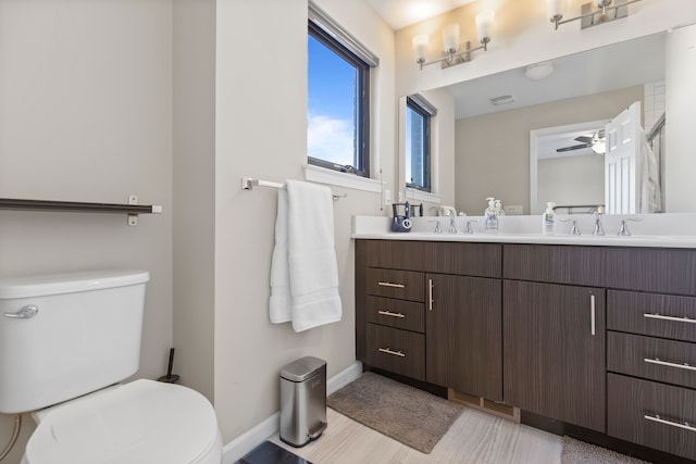 bathroom featuring double vanity, a sink, and toilet