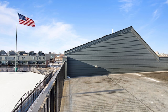 view of home's exterior featuring a balcony, a residential view, and uncovered parking