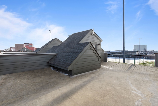 exterior space featuring a shingled roof and fence