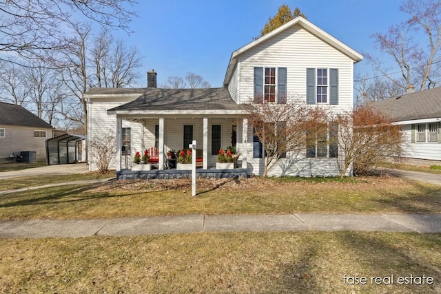 view of front of home featuring a porch, a front yard, and a chimney