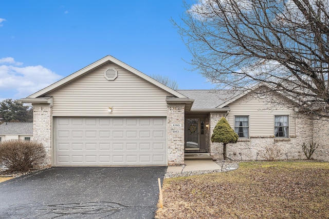 ranch-style house featuring a garage, brick siding, driveway, and roof with shingles