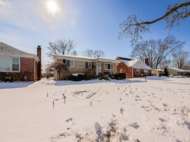 view of front of property with a chimney and brick siding