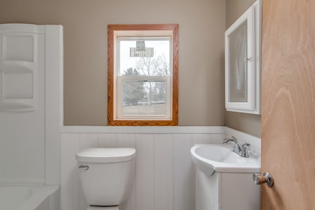 full bathroom with toilet, vanity, and wainscoting