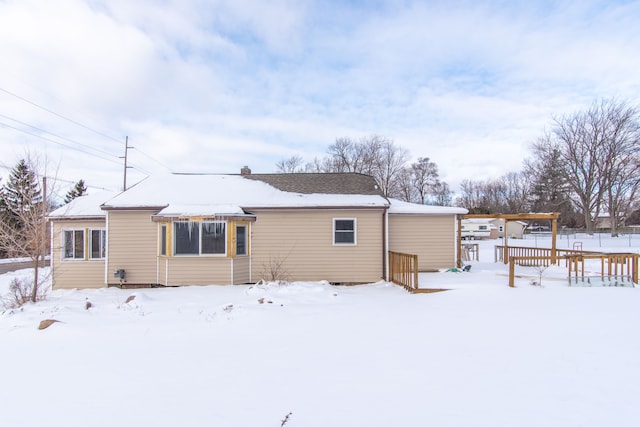 snow covered house featuring fence