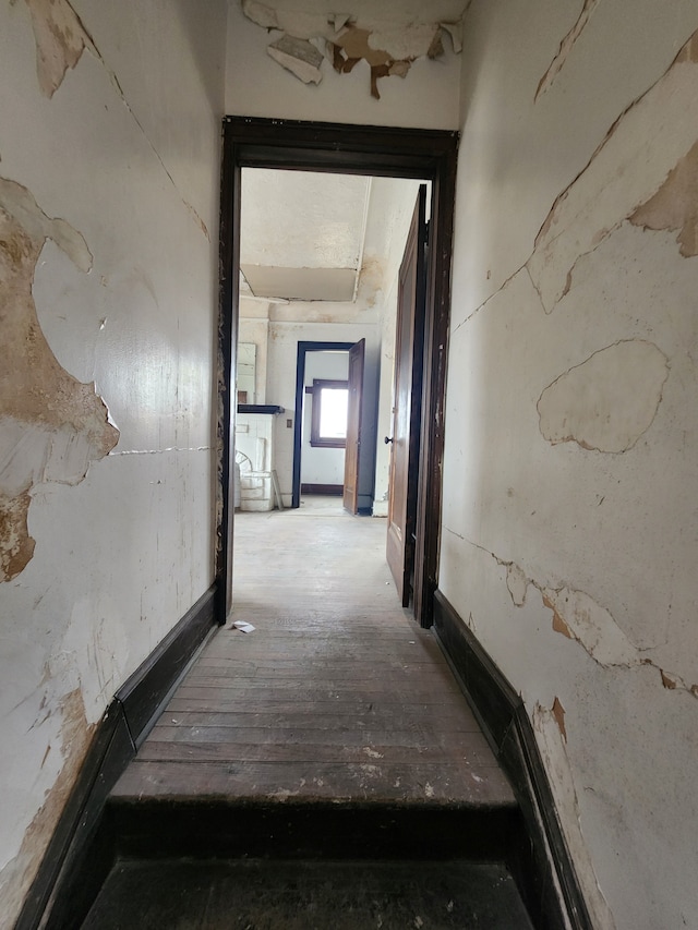 corridor with hardwood / wood-style flooring