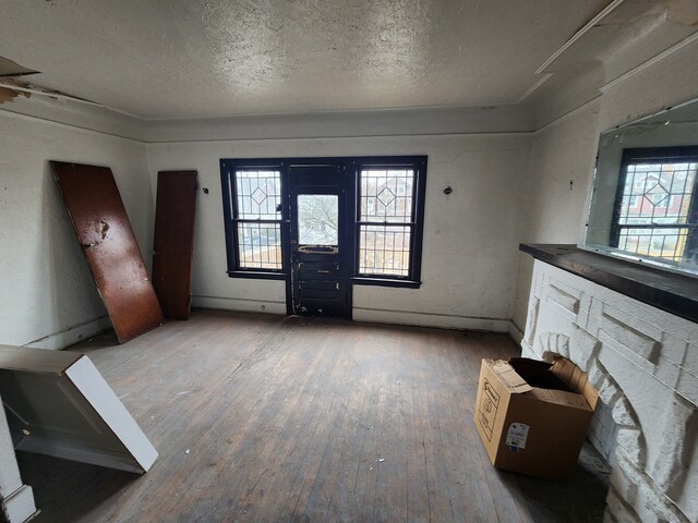 entryway featuring a textured ceiling, baseboards, and hardwood / wood-style floors