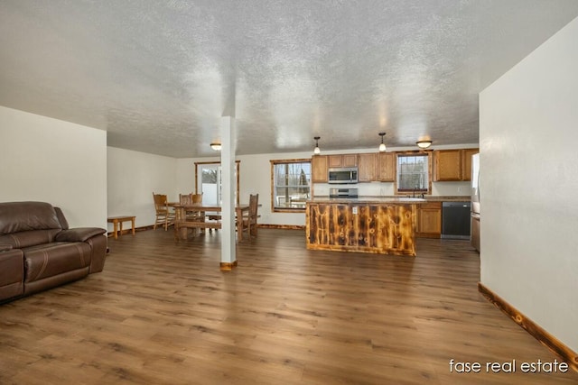 living area with a textured ceiling, dark wood-type flooring, and baseboards