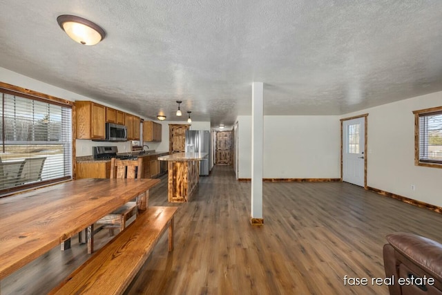 dining space with dark wood-style floors, baseboards, and a textured ceiling