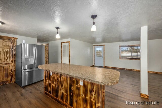 kitchen featuring dark wood-style floors, a textured ceiling, a center island, and stainless steel fridge with ice dispenser