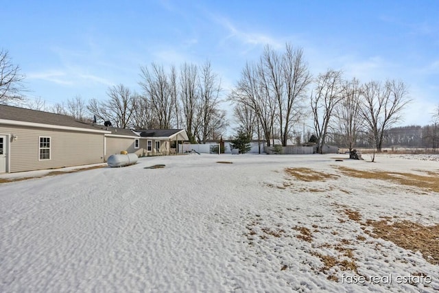 yard layered in snow with an attached garage