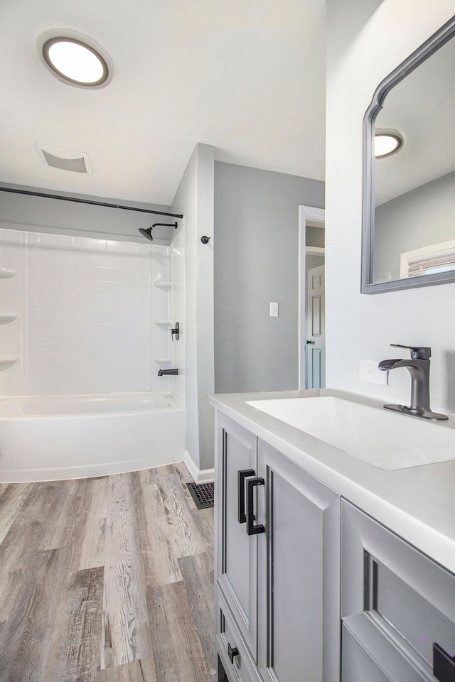 bathroom with vanity, wood finished floors, and washtub / shower combination