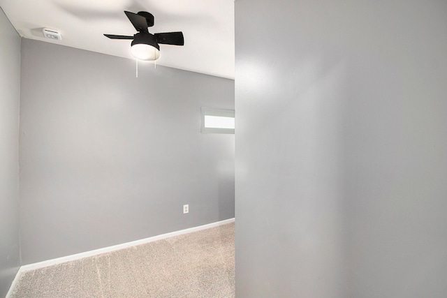 carpeted spare room with baseboards and a ceiling fan