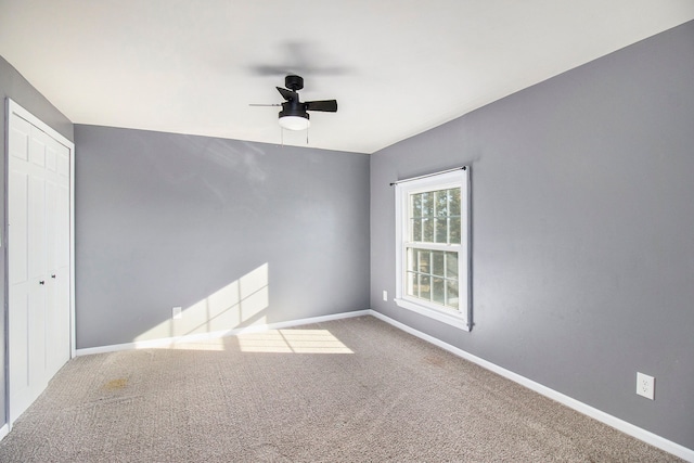 empty room featuring carpet, baseboards, and ceiling fan