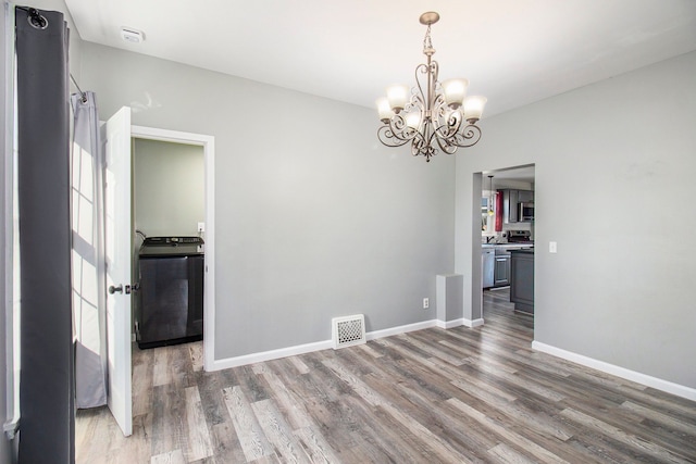 interior space featuring washer / clothes dryer, visible vents, baseboards, and wood finished floors