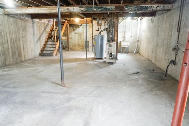 unfinished below grade area featuring water heater and stairs