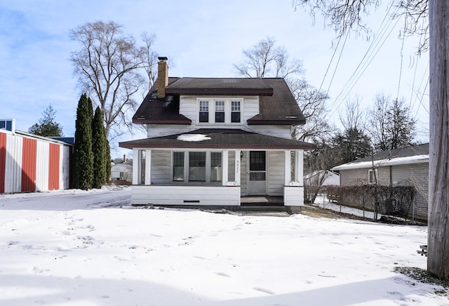 view of front facade featuring a chimney and a porch