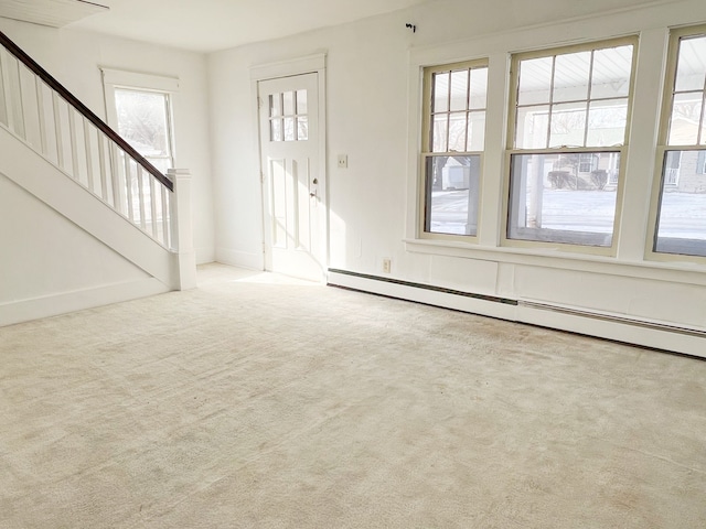 entrance foyer with carpet floors, baseboards, stairway, and baseboard heating