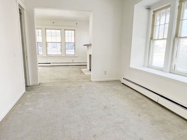 spare room with a baseboard heating unit, carpet, a baseboard radiator, and a healthy amount of sunlight