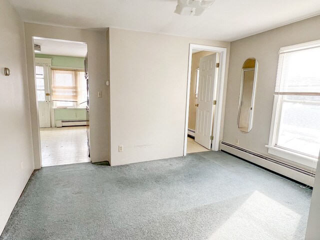 spare room with a baseboard radiator, healthy amount of natural light, and carpet