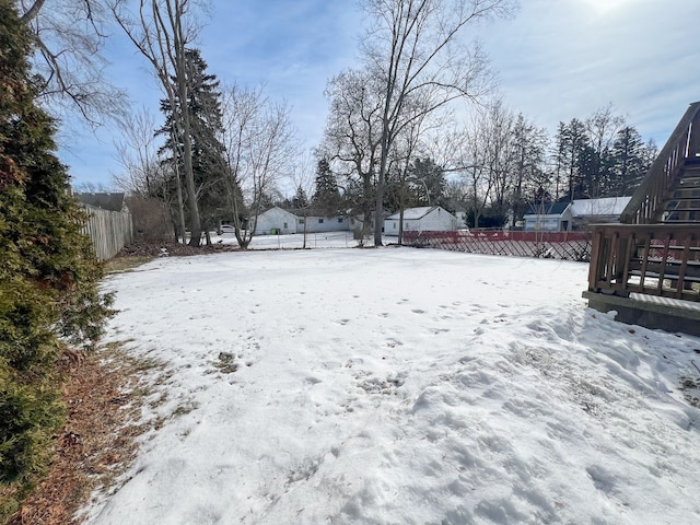 snowy yard featuring a fenced backyard