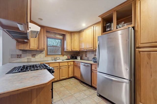 kitchen featuring stainless steel appliances, light countertops, a sink, and backsplash