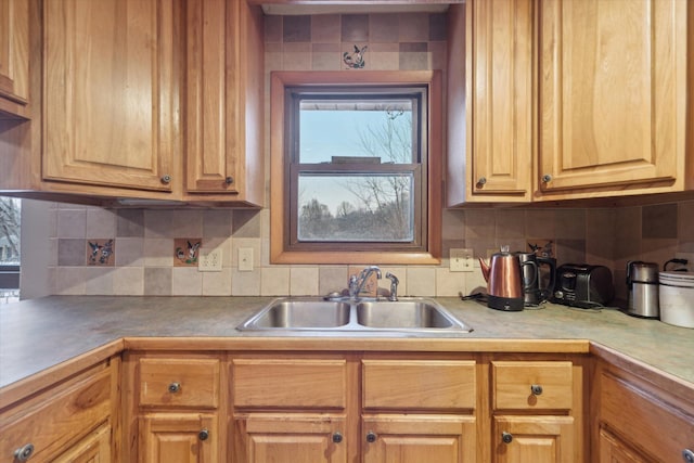 kitchen featuring light countertops, backsplash, and a sink