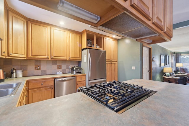 kitchen with decorative backsplash, stainless steel appliances, crown molding, light countertops, and a sink