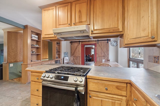 kitchen featuring stainless steel gas range oven, a barn door, under cabinet range hood, decorative backsplash, and open shelves