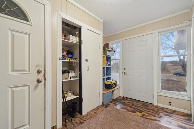 foyer featuring wooden walls and crown molding